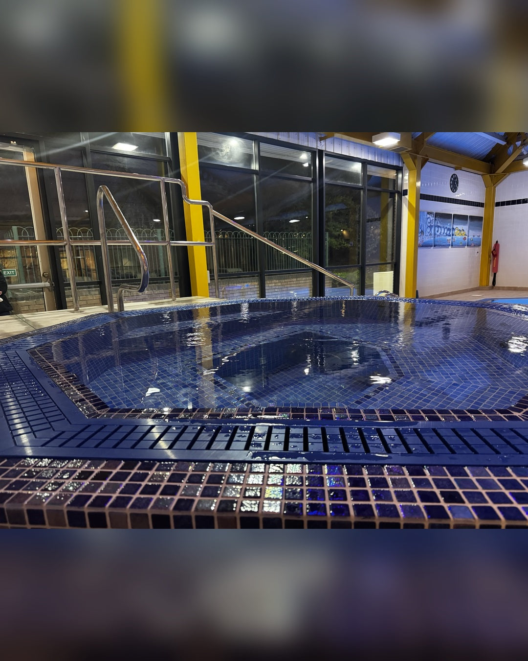 Blue mosaic tiled spa filled with water